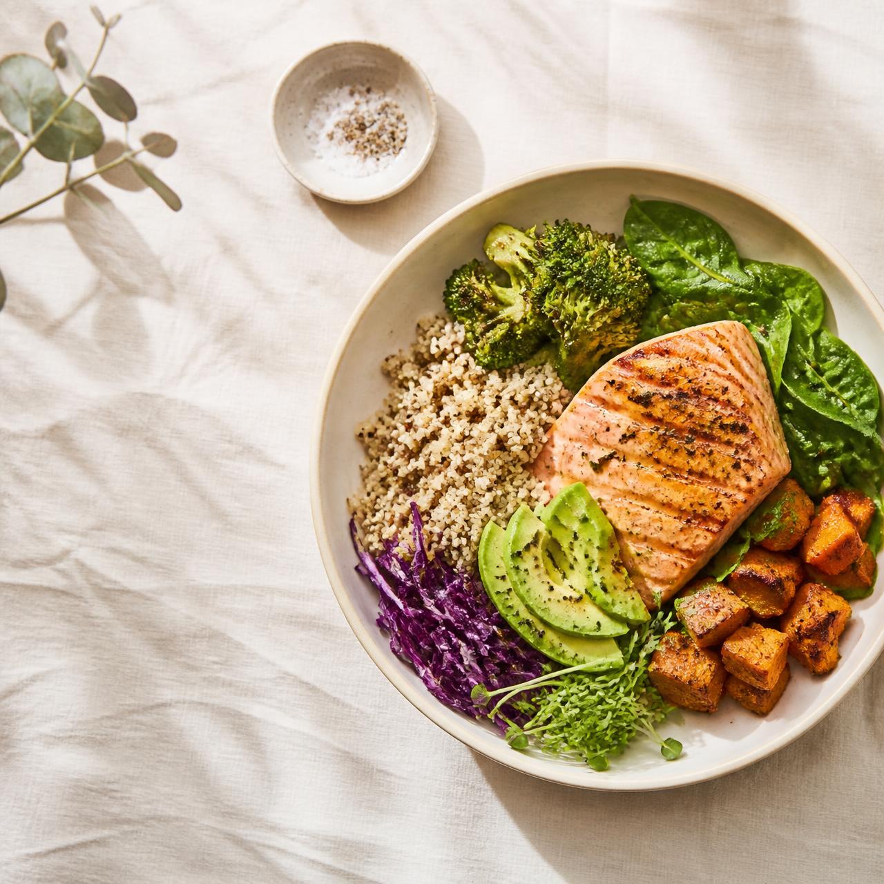 Balanced meal bowl with salmon, quinoa, avocado and vegetables